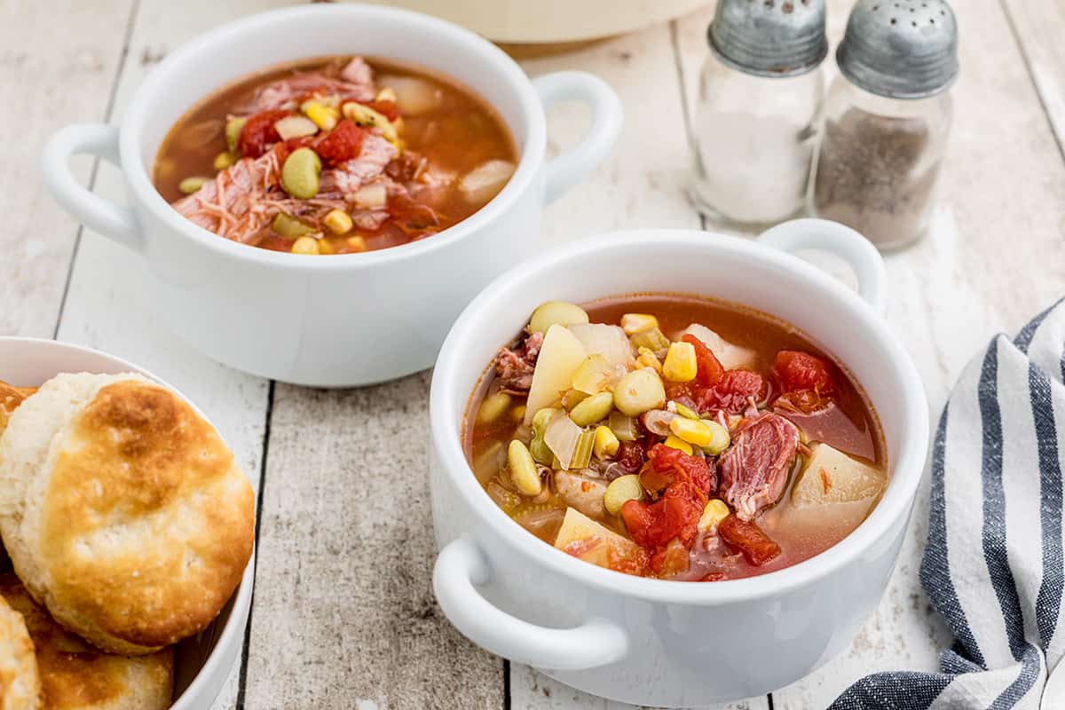 Two bowls of soup on a wooden background.