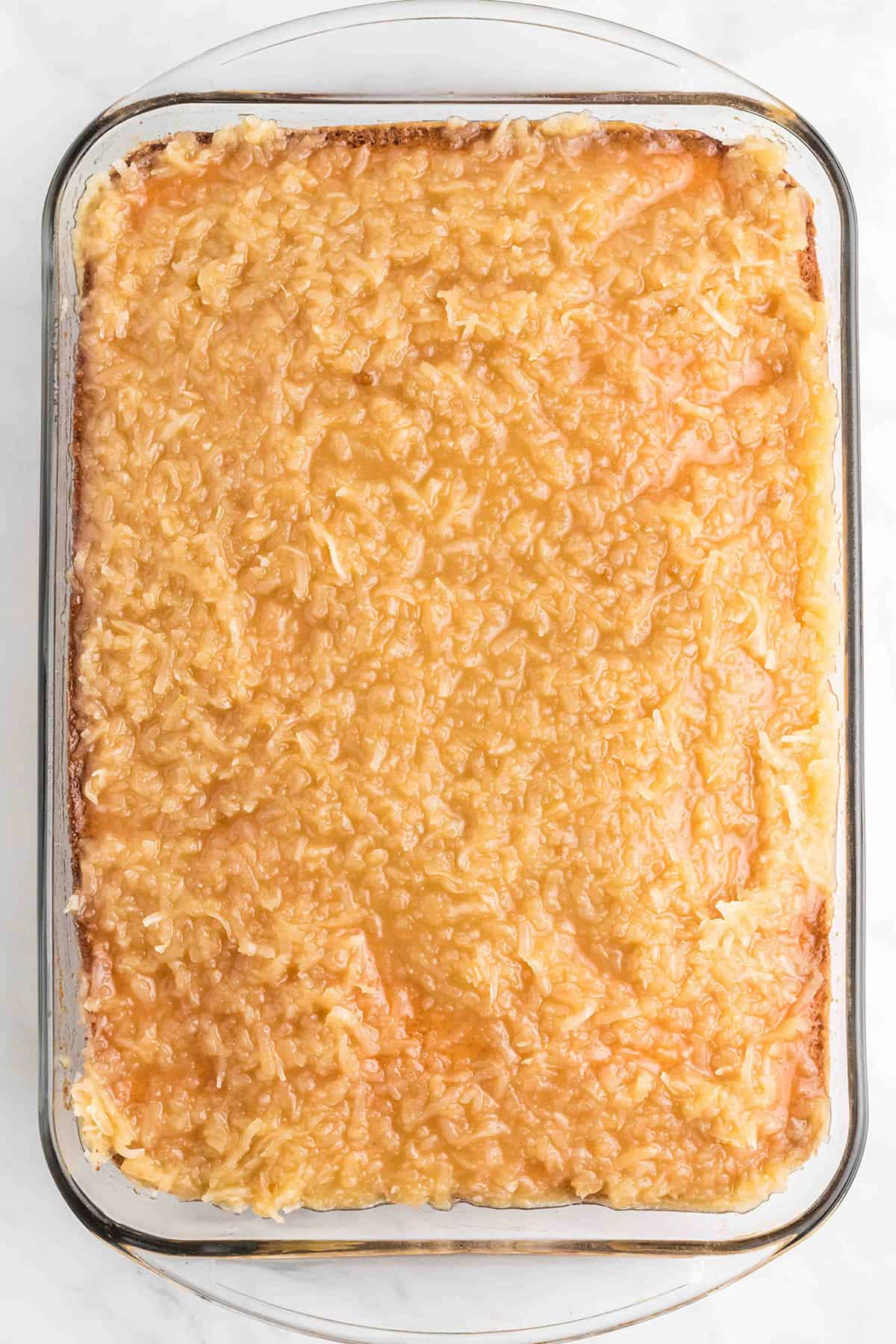 Coconut topping spread over baked cake layer.