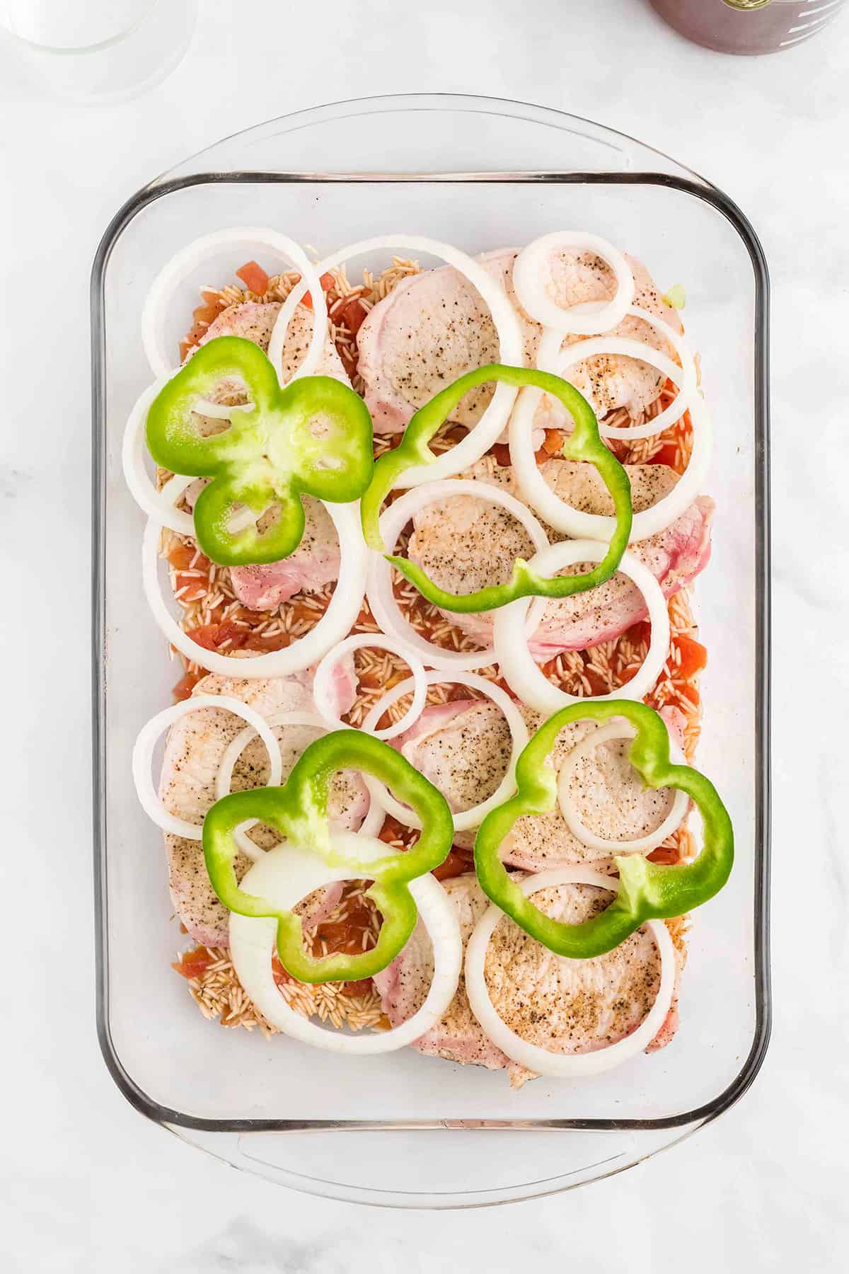 Onions and bell pepper added to top of pork chops.