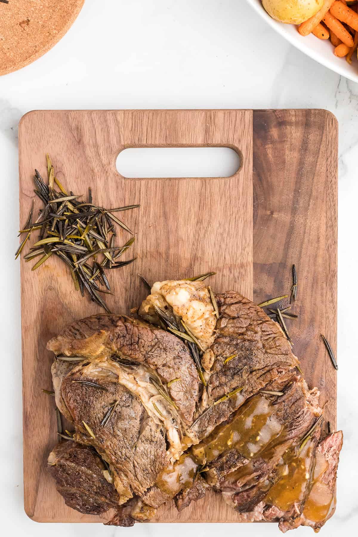 Cooked, sliced roast on a wooden board.