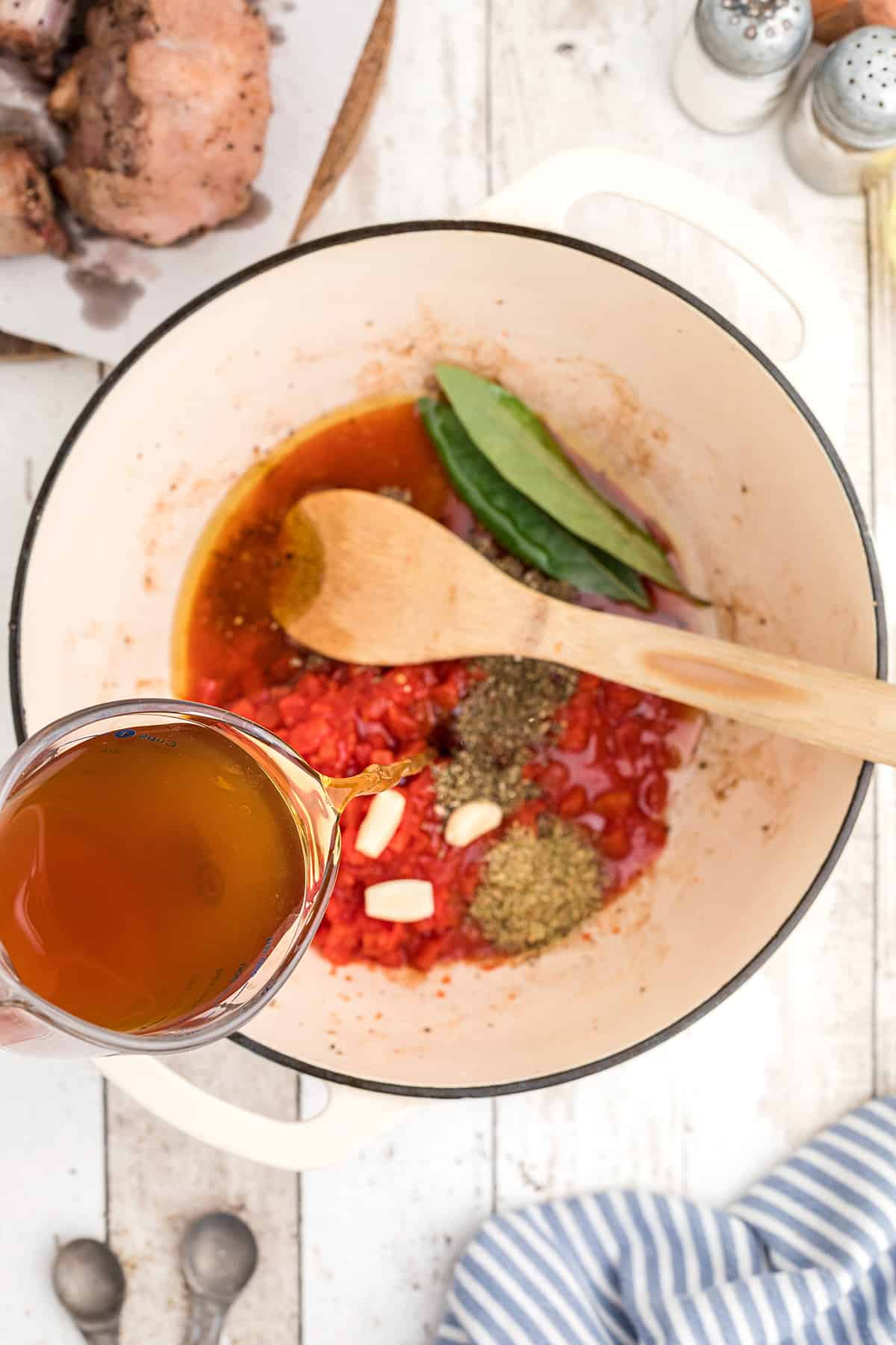 Tomatoes, broth, and spices added to the pan.