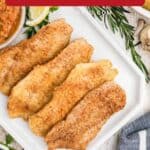 Four pieces of pan fried fish on a white plate, served with herbs, potatoes, and red pepper sauce on the side.