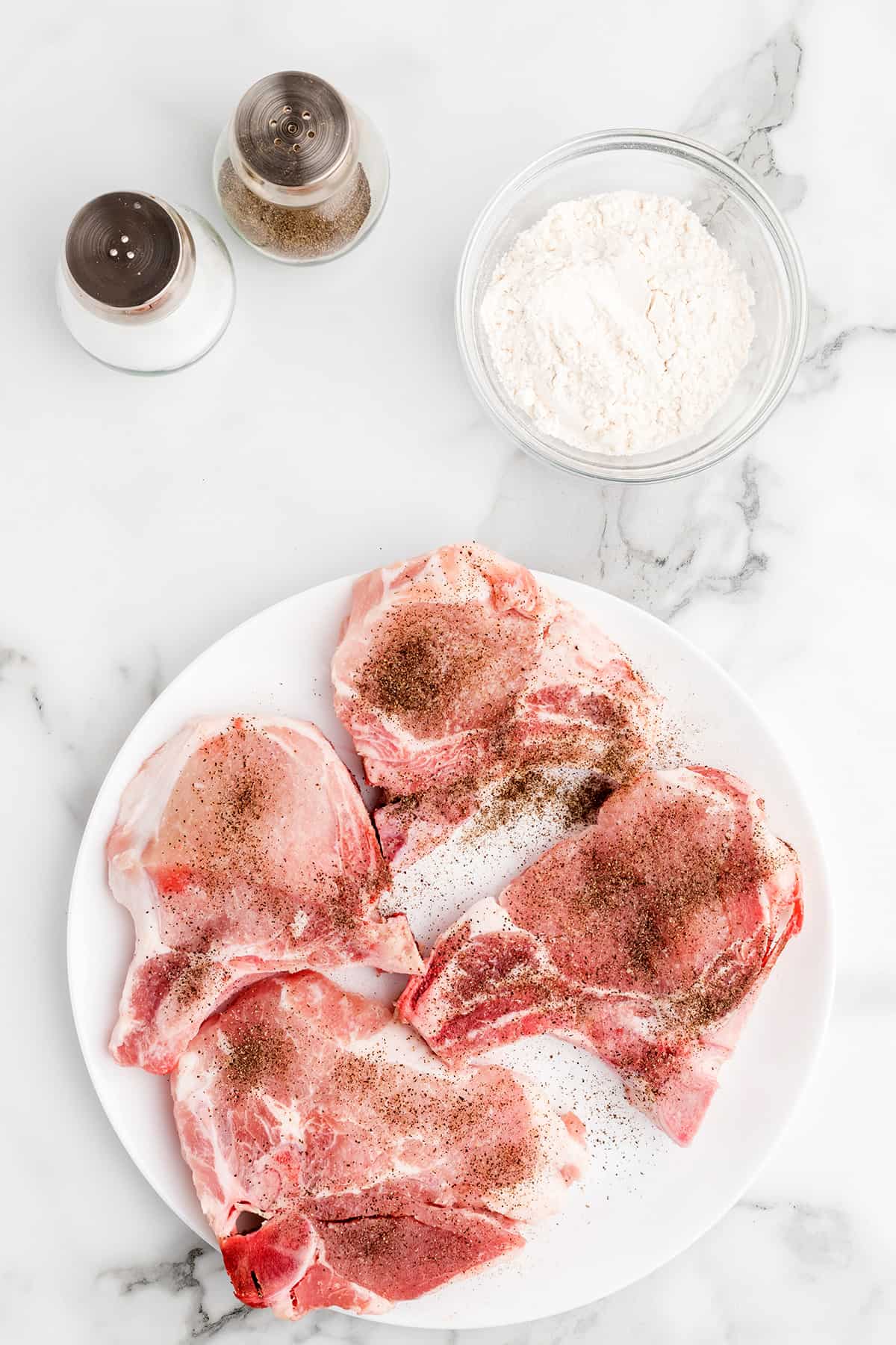 Seasoned pork chops on a plate.