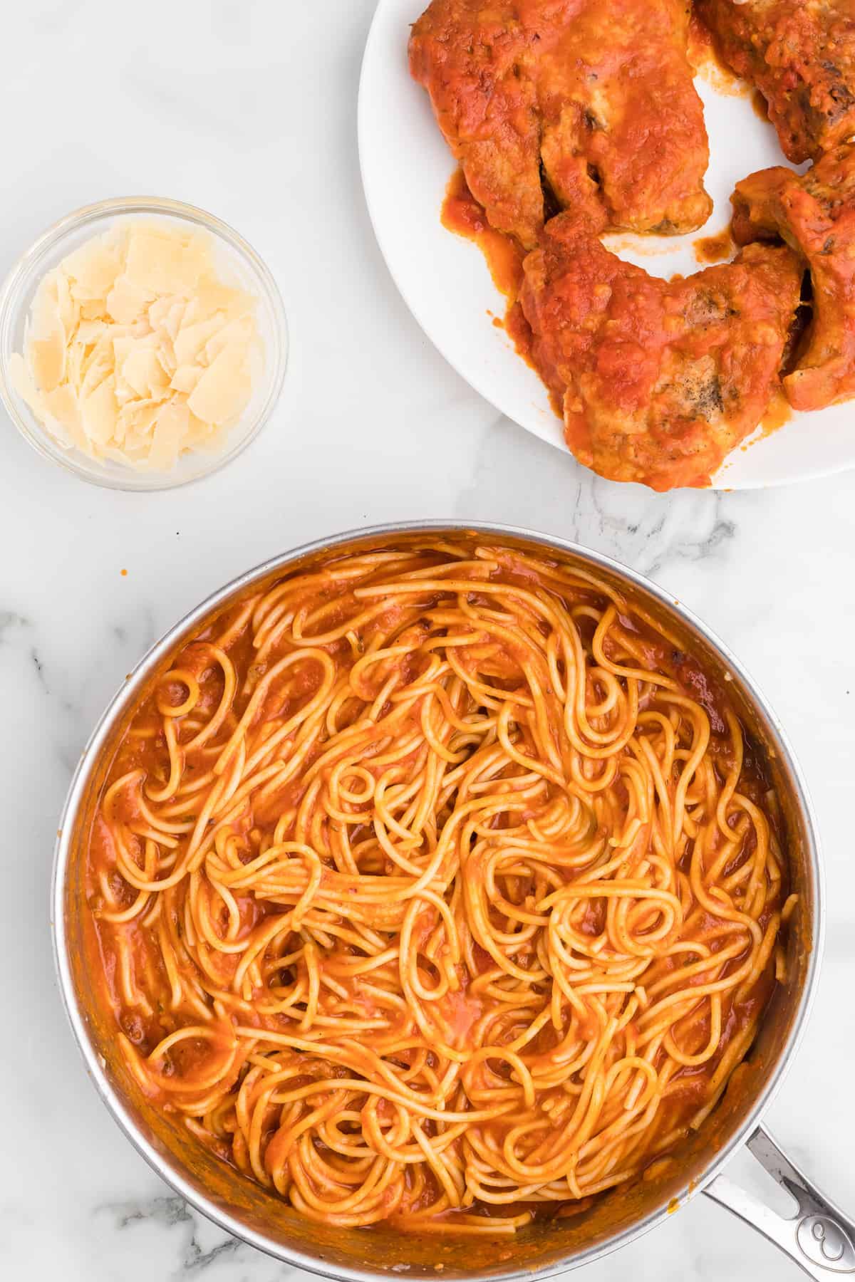 Spaghetti tossed with sauce in a skillet.