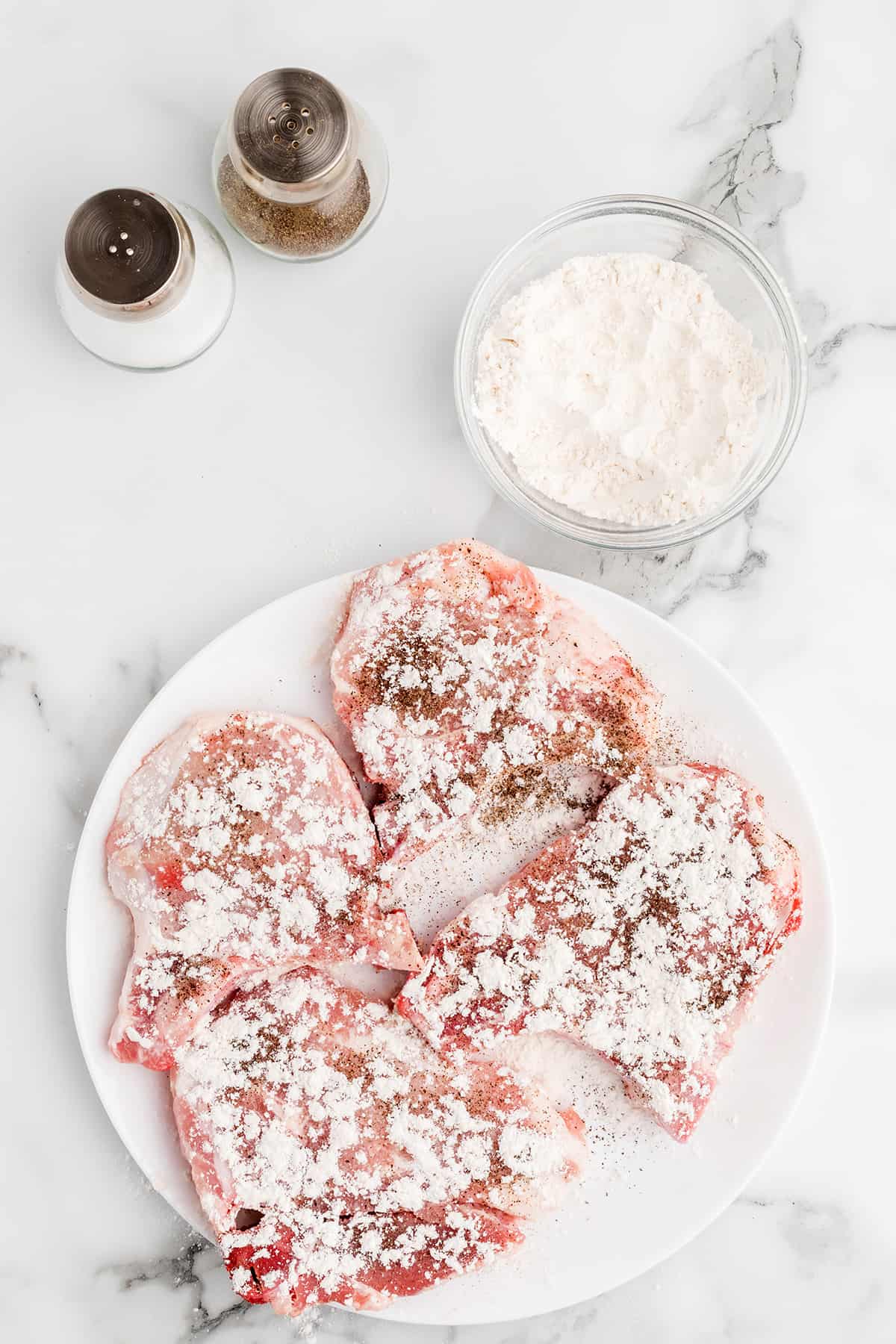 Pork chops with flour sprinkled over.