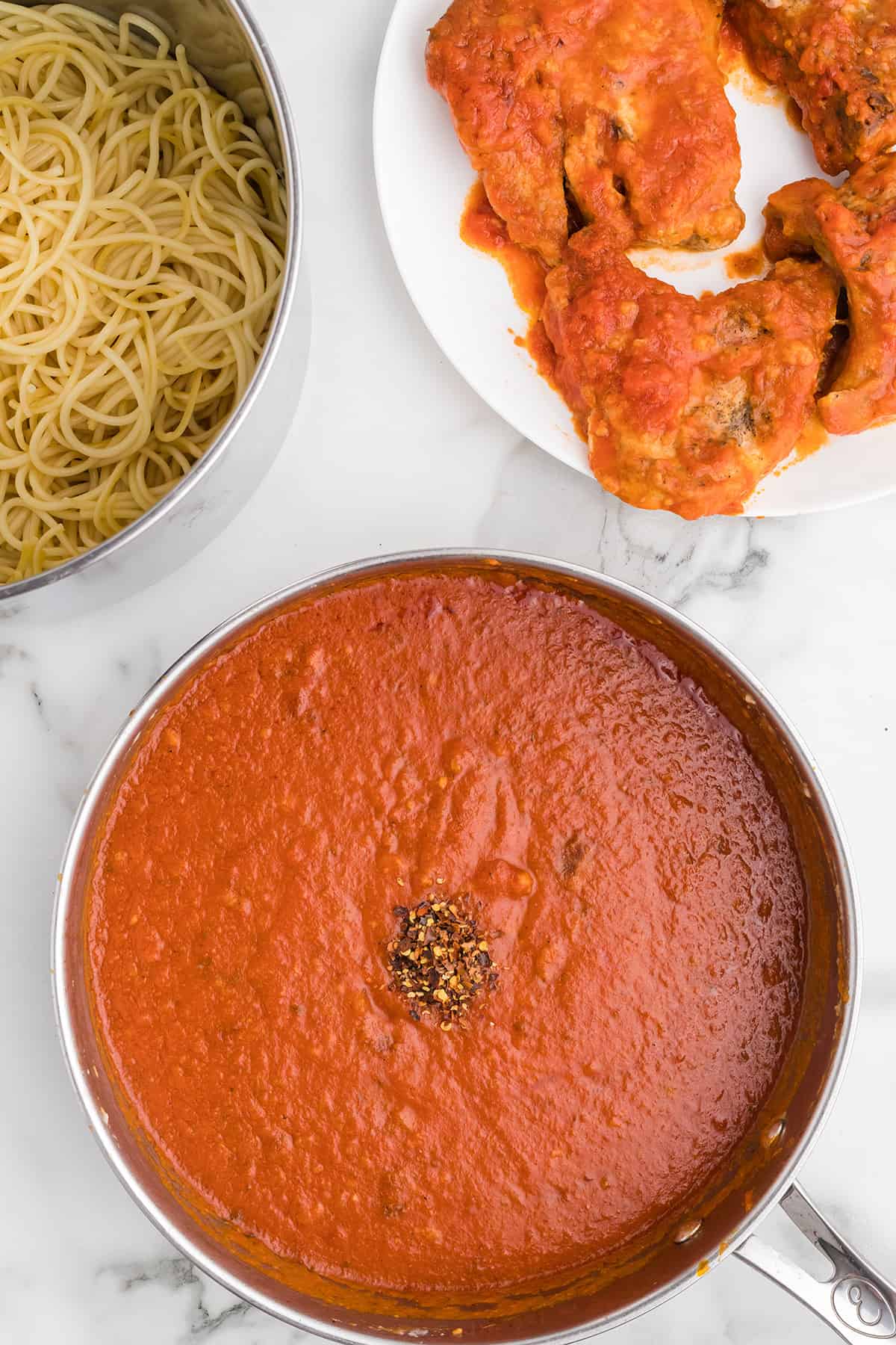Red pepper flakes added to marinara sauce.