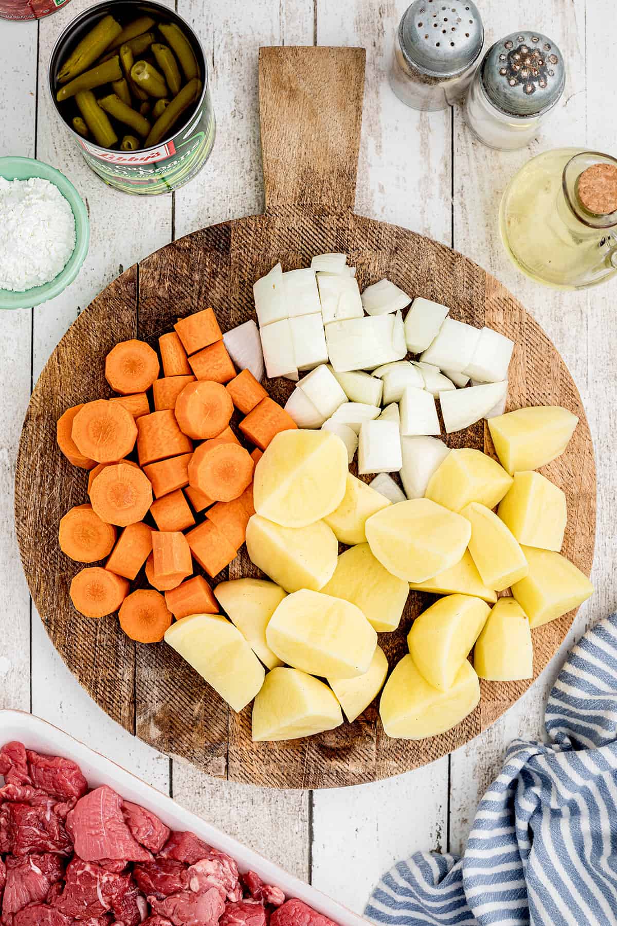 Cubed and diced vegetables on a cutting board.