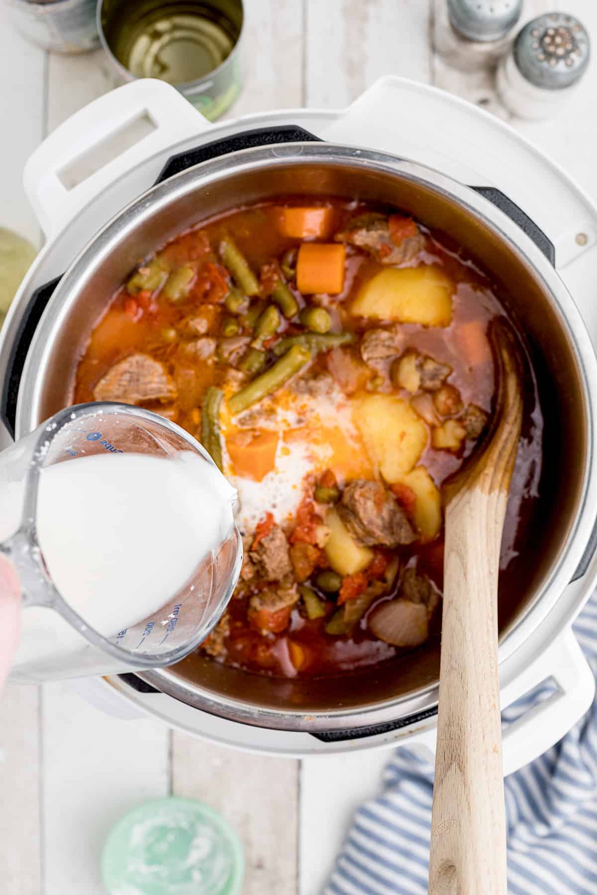 Adding cornstarch slurry to cooked stew,