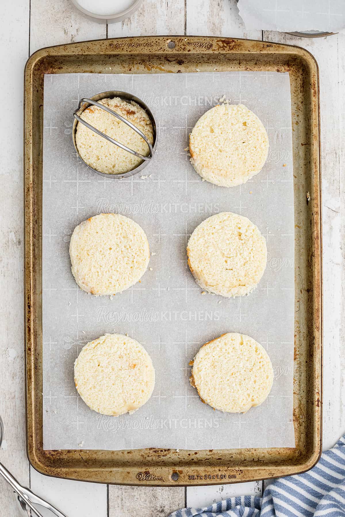 Cake rounds on a parchment lined baking sheet.