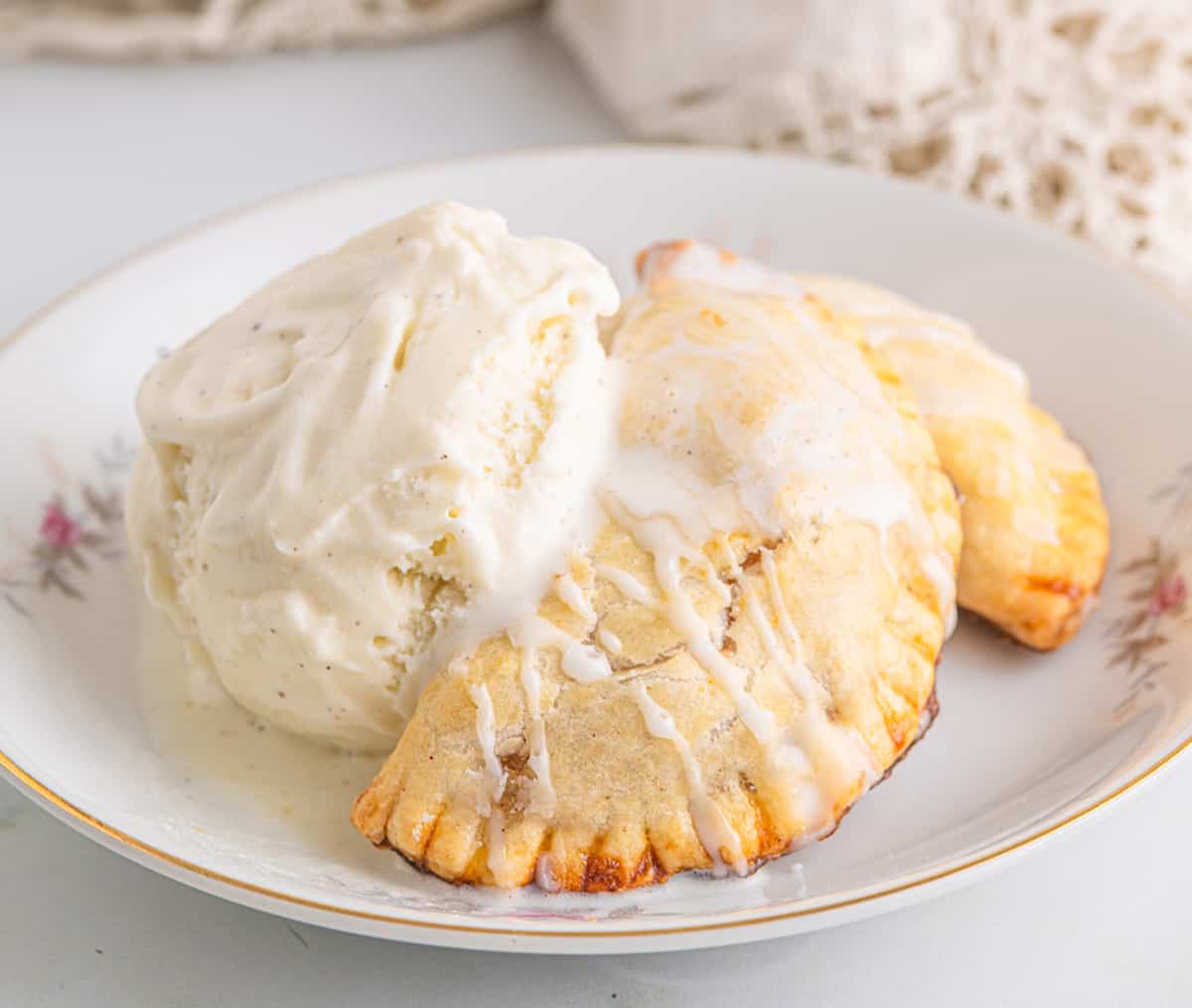 Hand pies with a scoop of vanilla ice cream on a serving dish.