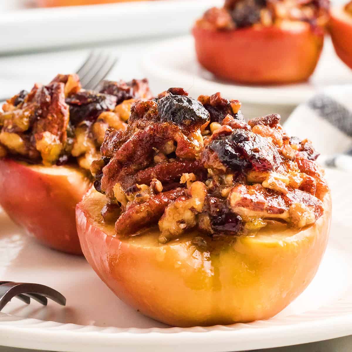 Two baked apple halves on a serving plate.