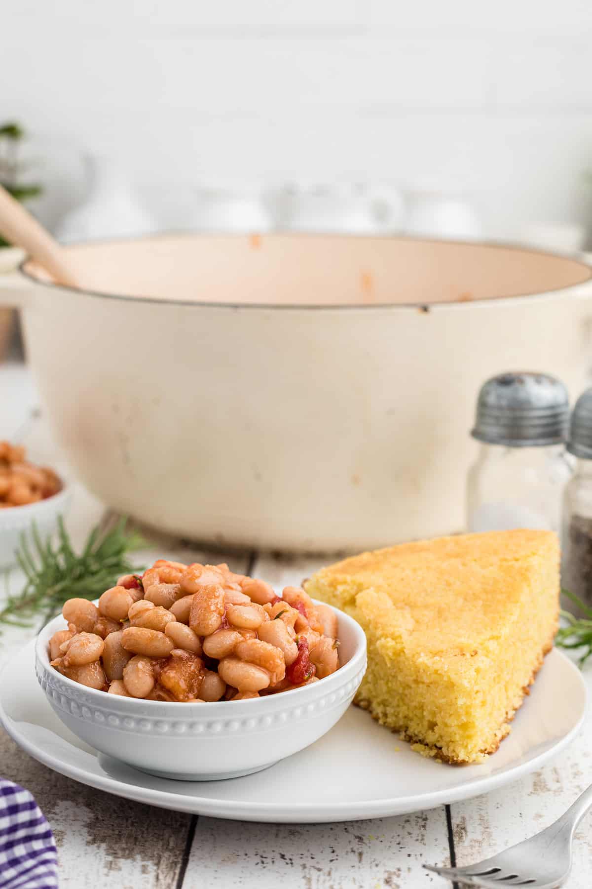 A serving of great northern beans in a white bowl.