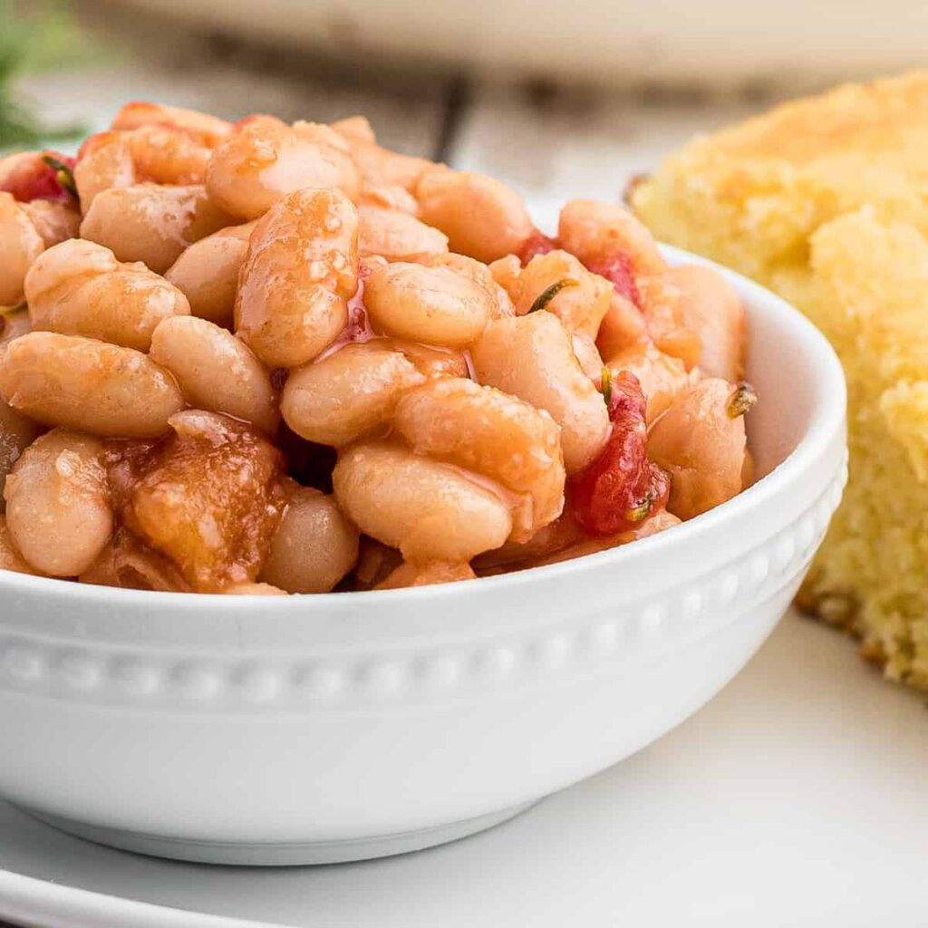 A serving of great northern beans in a white bowl.