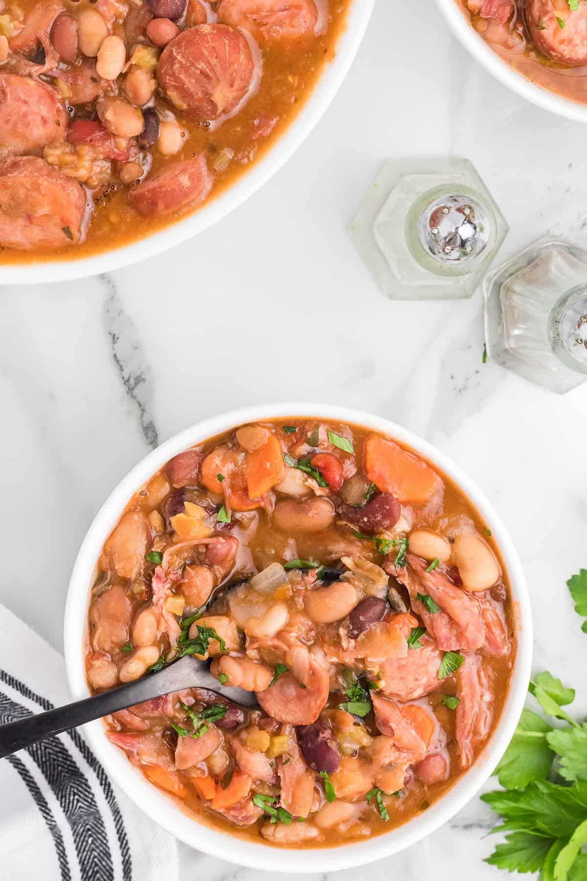 A serving of mixed bean soup in a white bowl.