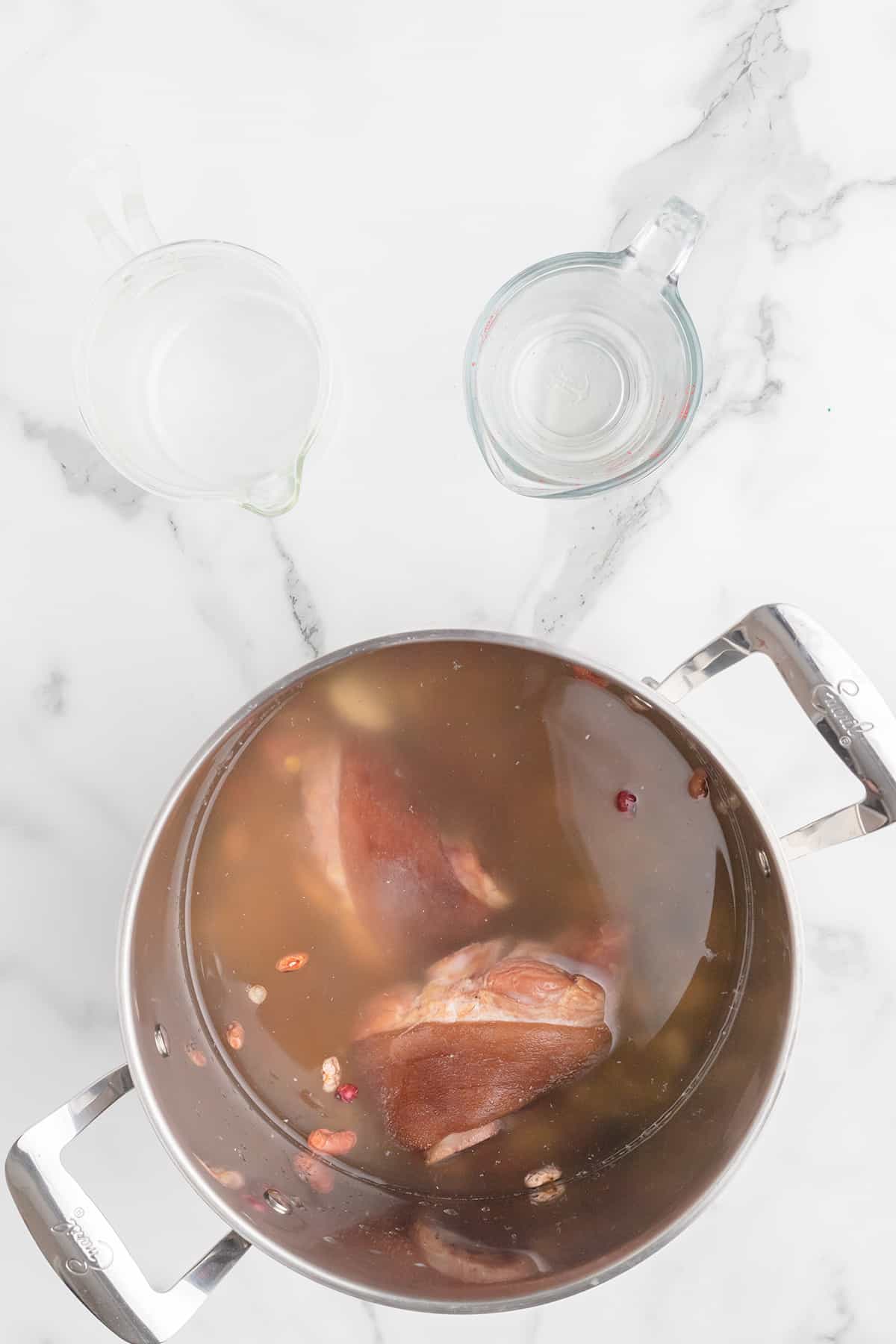 Beans and ham hocks with water in a large pot.