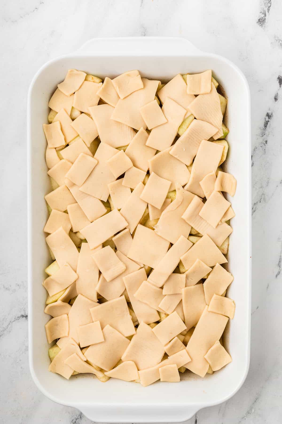 Pie crust pieces applied to top of the apple filling.