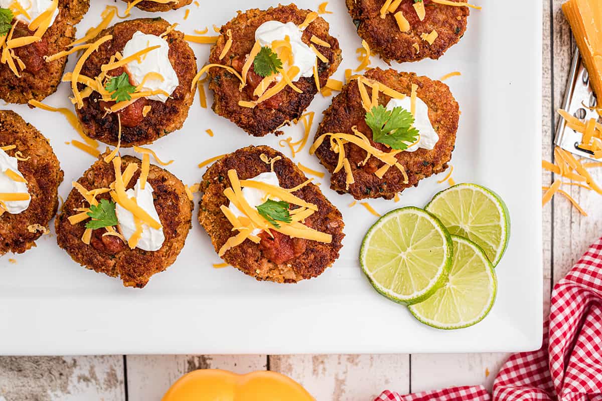 Finished pinto bean cakes on a white serving plate.