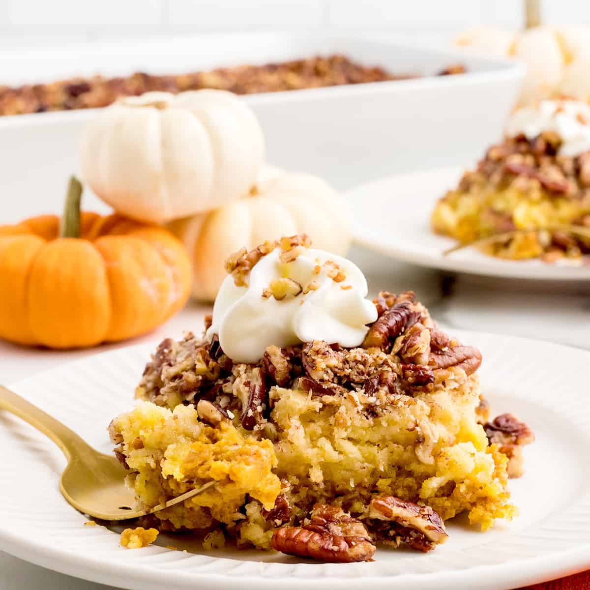 A slice of pumpkin pecan crunch cake on a white plate.