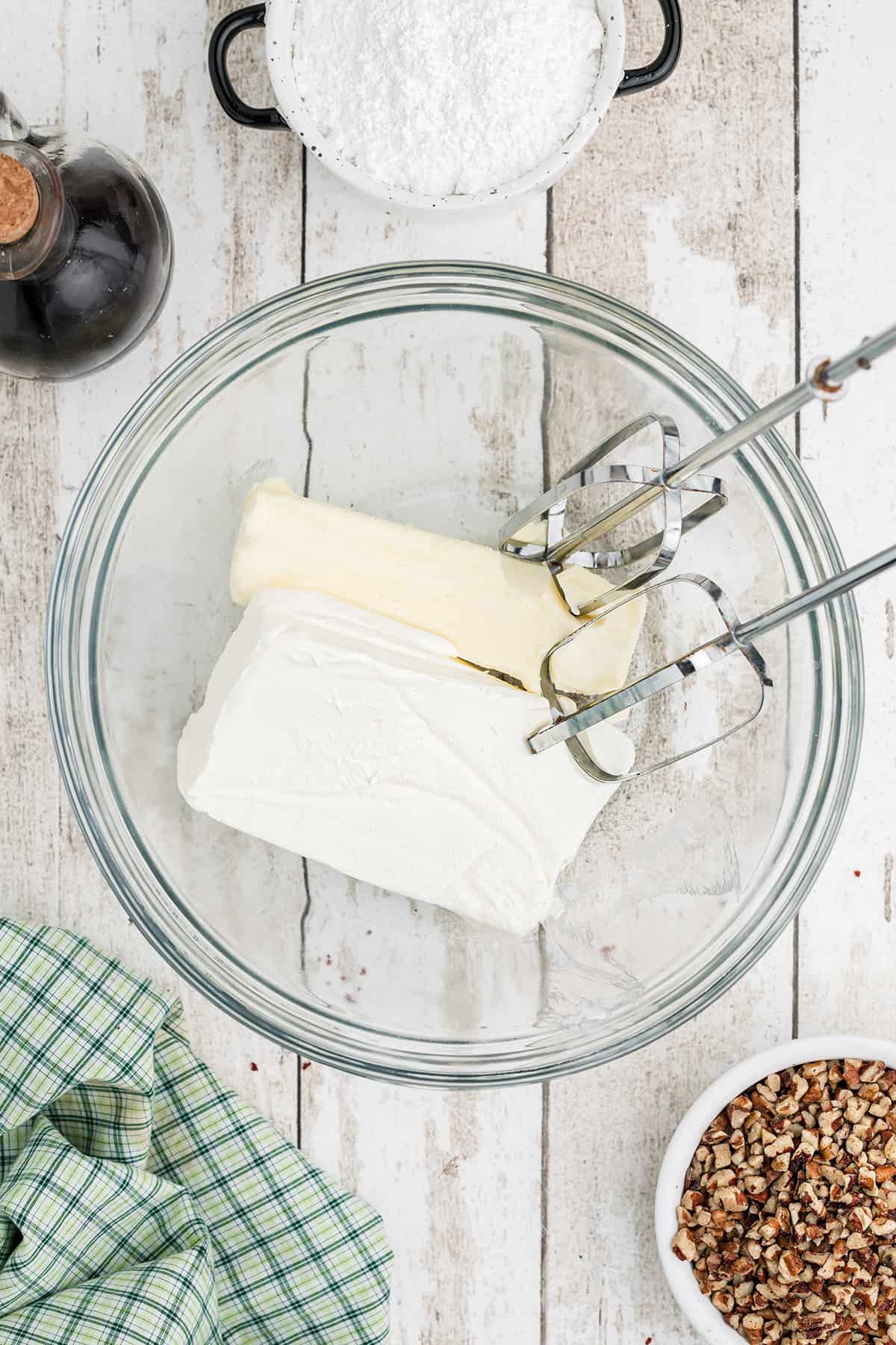 Beating butter and cream cheese in a bowl.