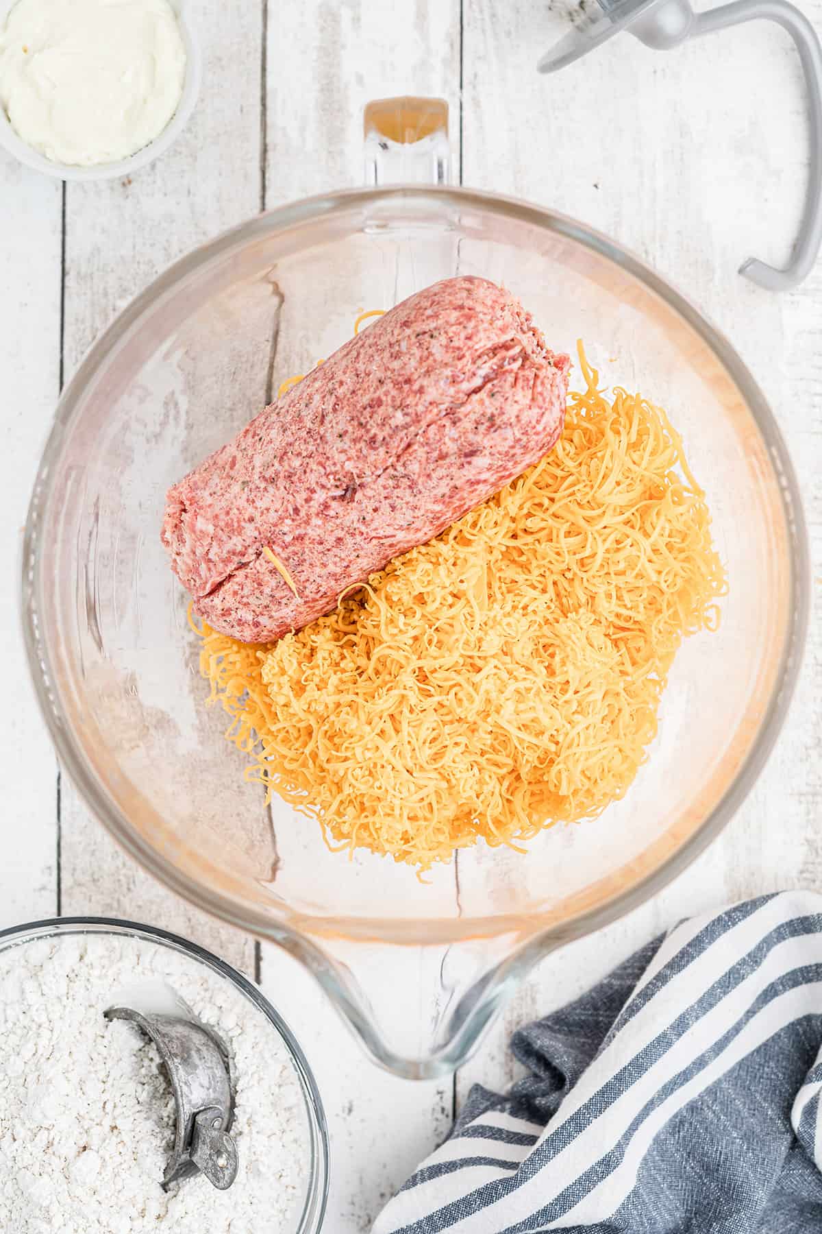 Sausage and grated cheese in a mixing bowl.