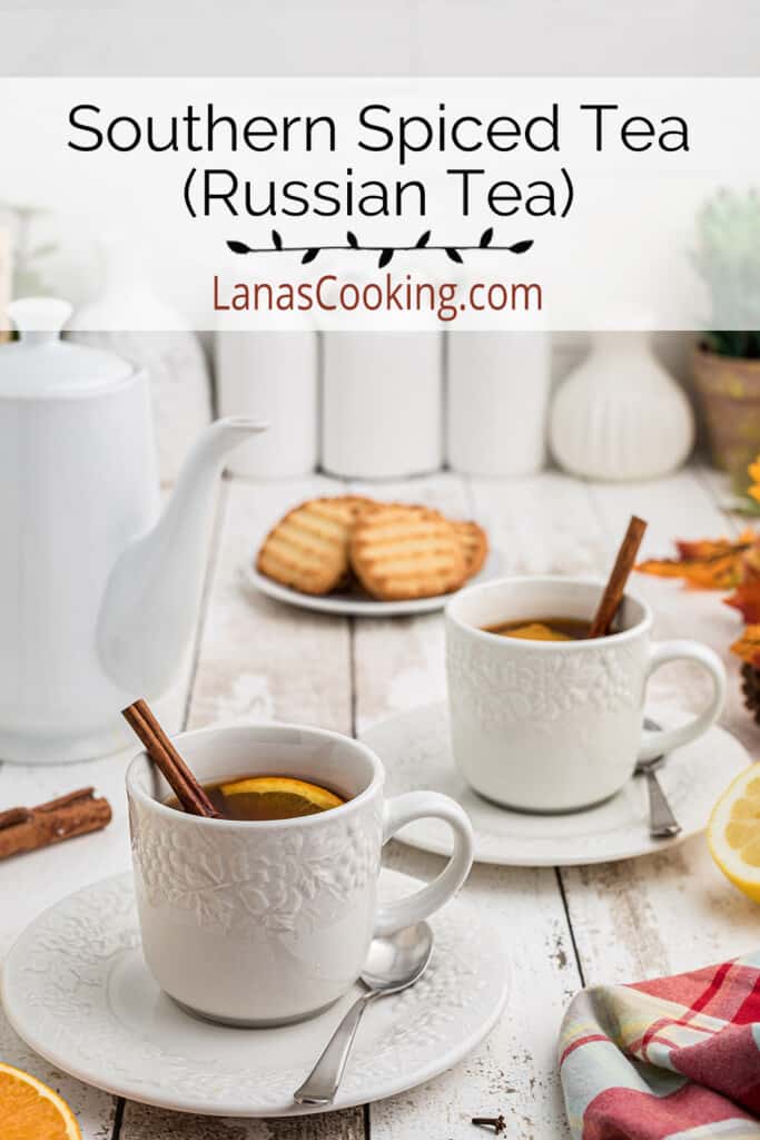 Two cups of spiced tea with a plate of cookies in the background.