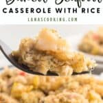 Fork holding a bite of baked seafood casserole with rice, with more casserole on a plate in the background.