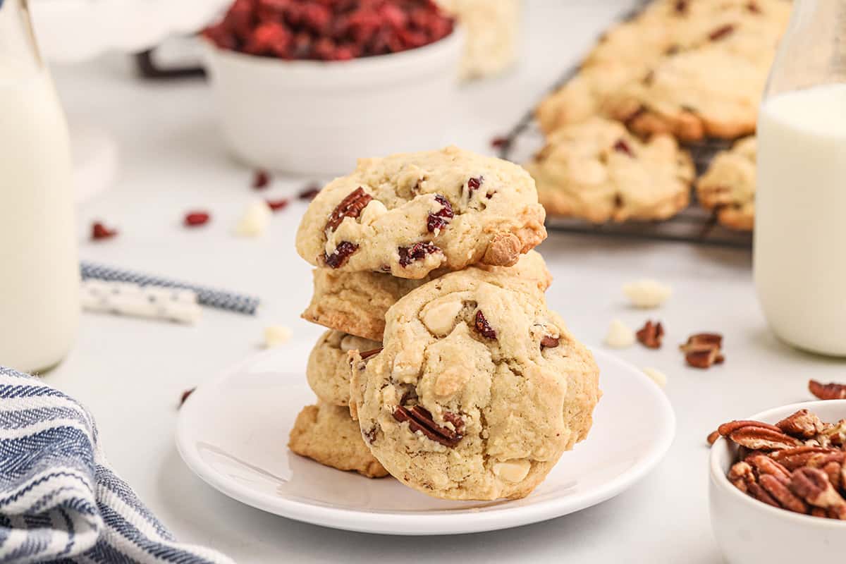 A stack of four cookies on a white plate.