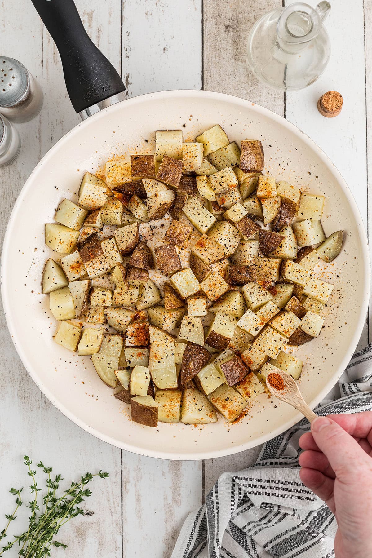 Potato cubes added to the butter and oil in the skillet.