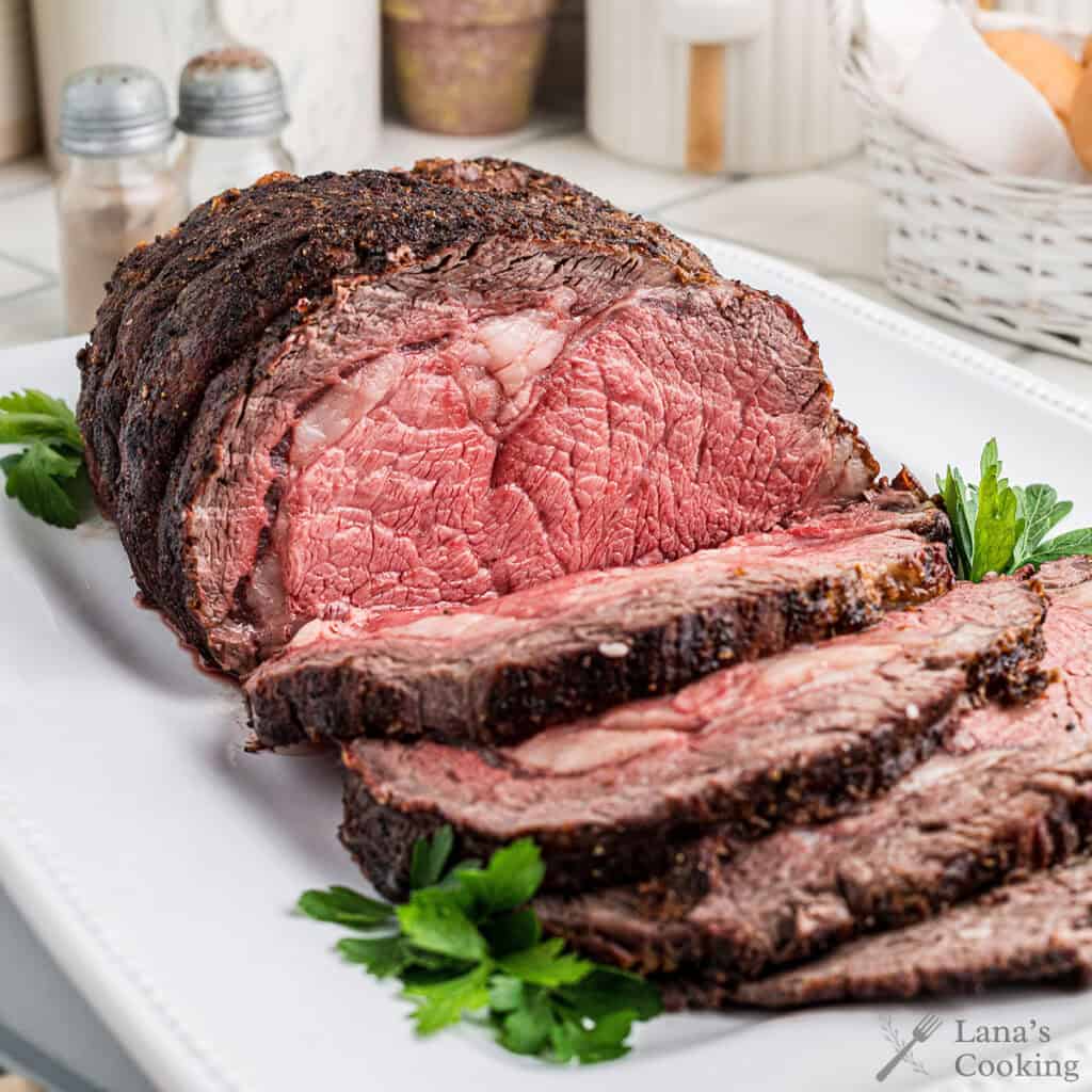 Sliced prime rib on a white plate.