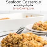 A serving of seafood casserole on a white plate with a fork on the side.