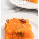 A square serving of orange Sunshine Salad with pecans on a white plate, another plate in the background.