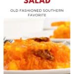 Bright orange sunshine salad with shredded carrots and gelatin, served on a white plate with a fork.