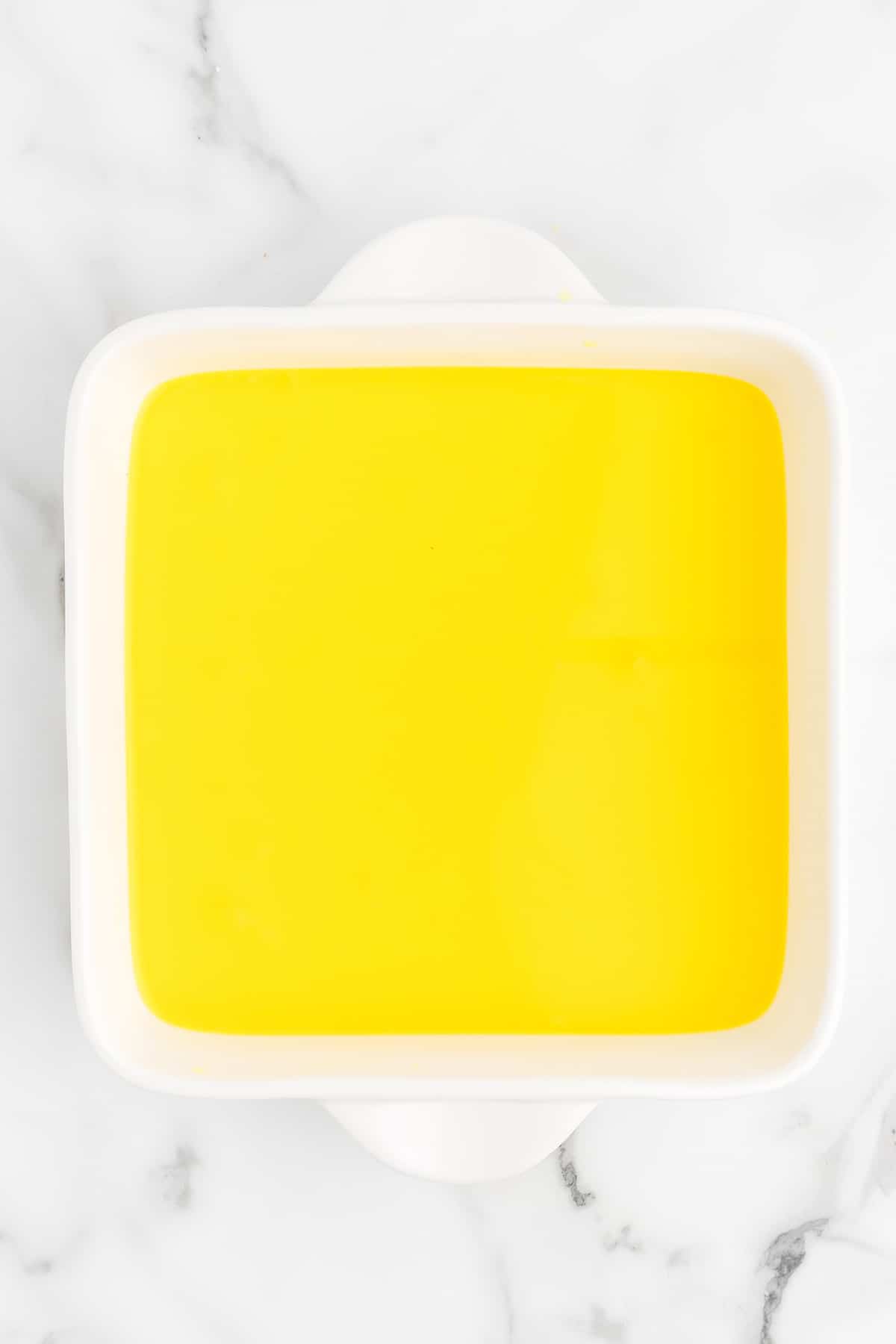 Jello and juice mixture in a square dish.