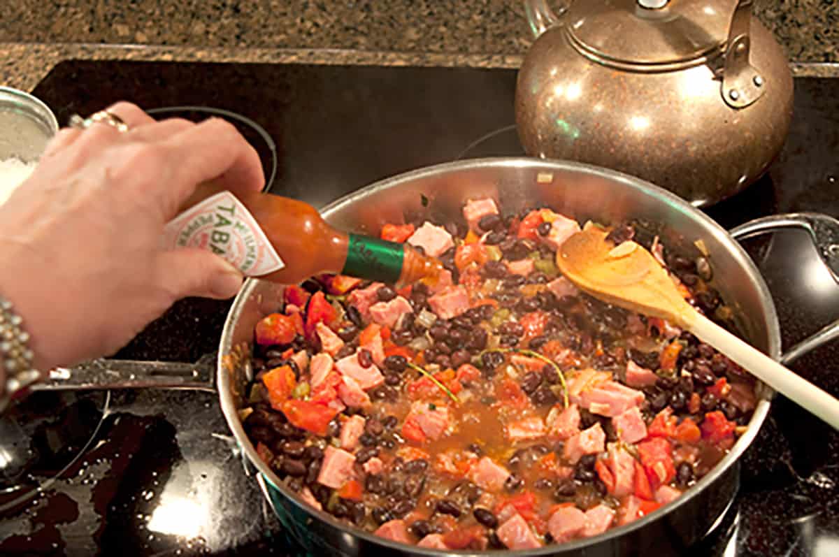 Adding Tabasco sauce to the pan.
