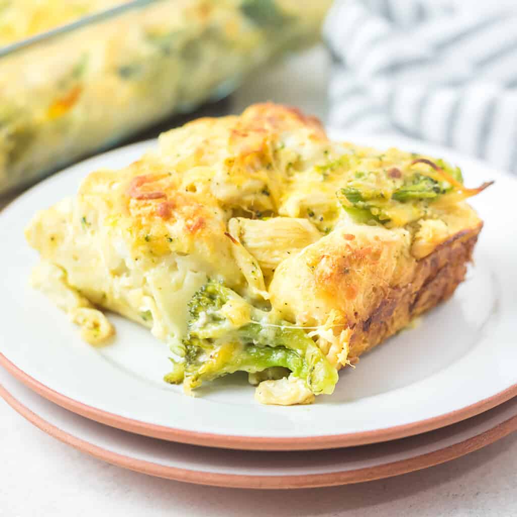 A serving of cheesy chicken broccoli casserole on a white plate.