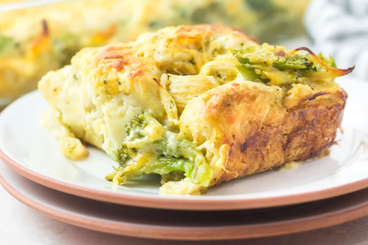 A serving of cheesy chicken broccoli casserole on a white plate.