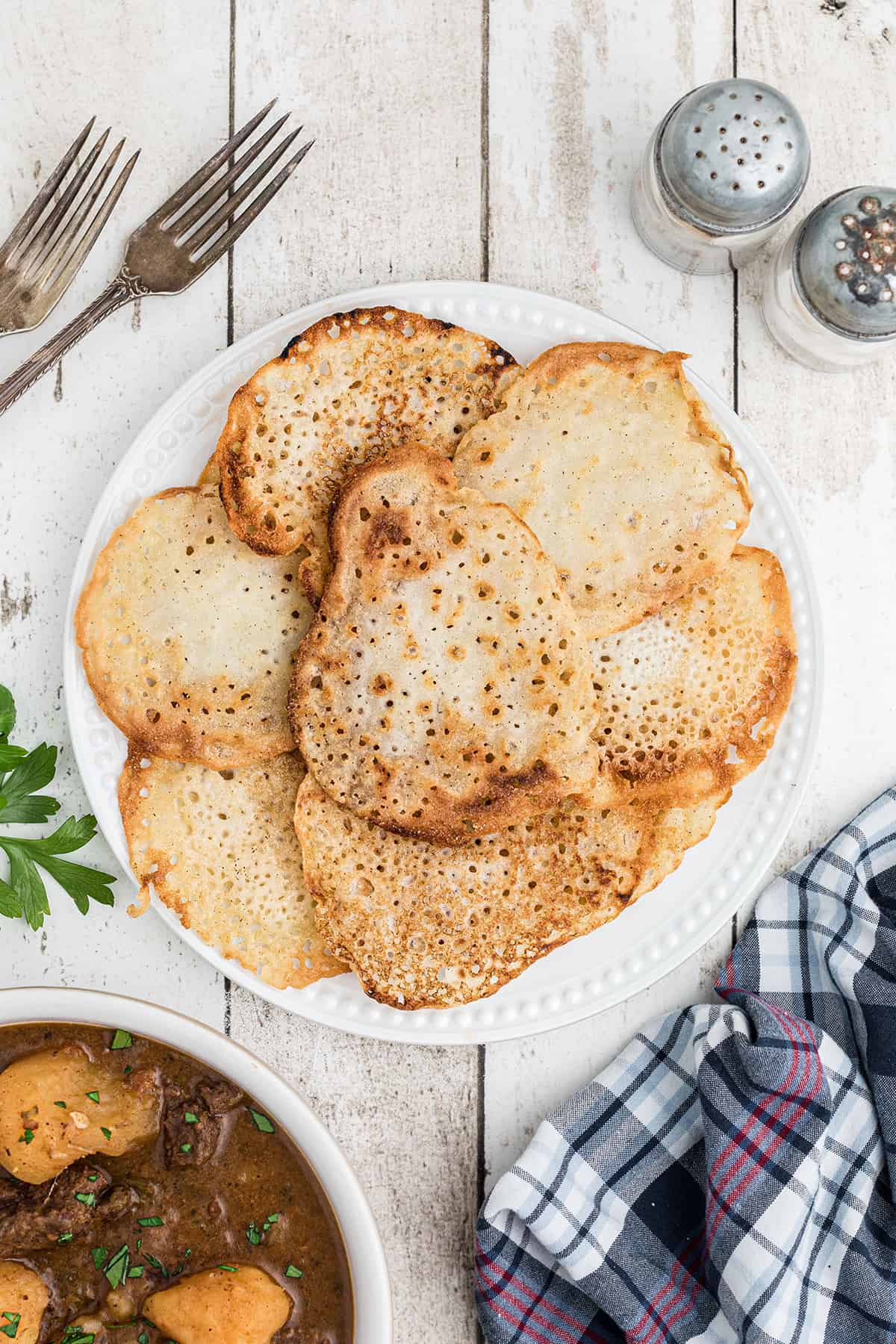 A stack of lacy cornbread on a white plate.