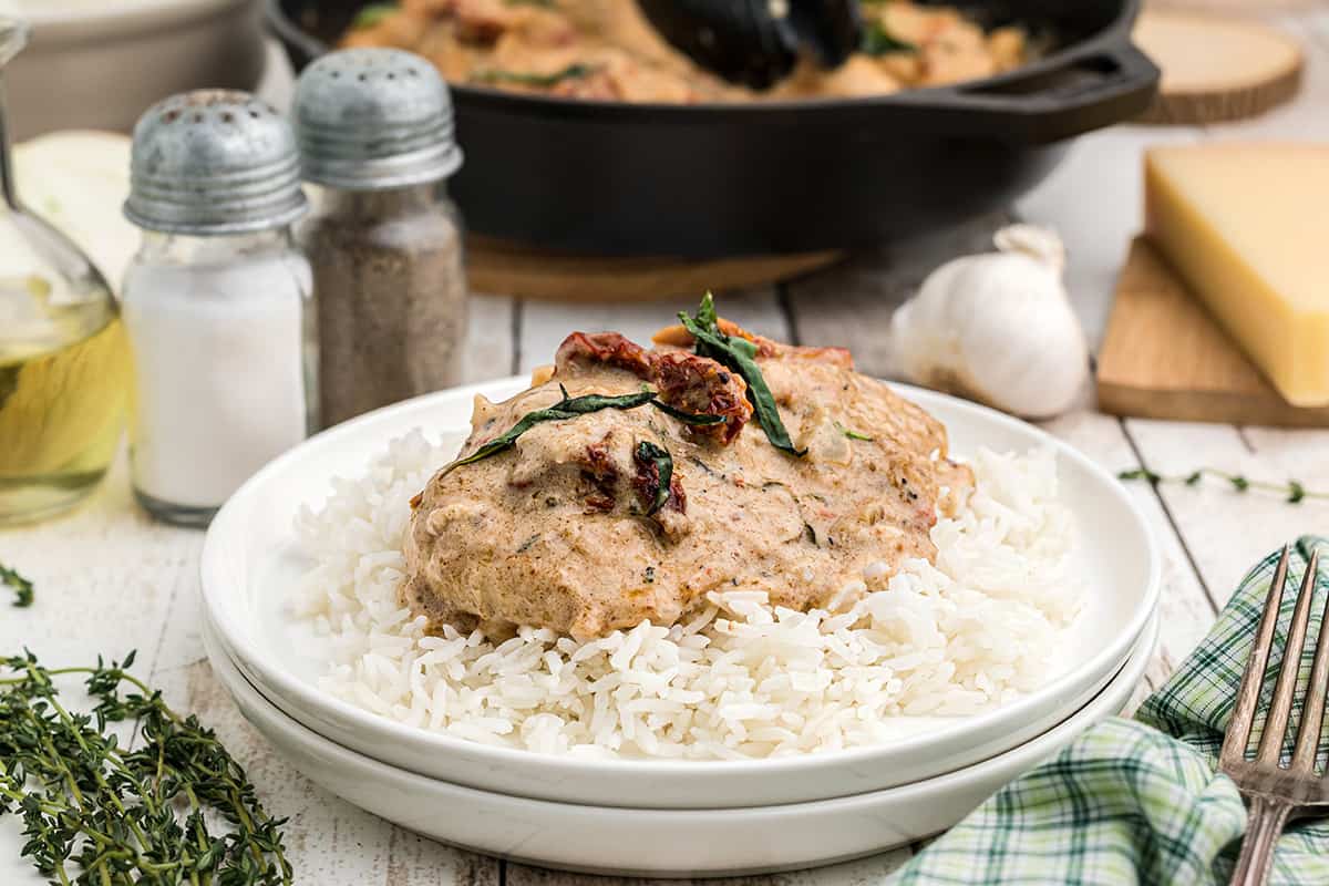 Marry Me Chicken over rice in a white bowl.