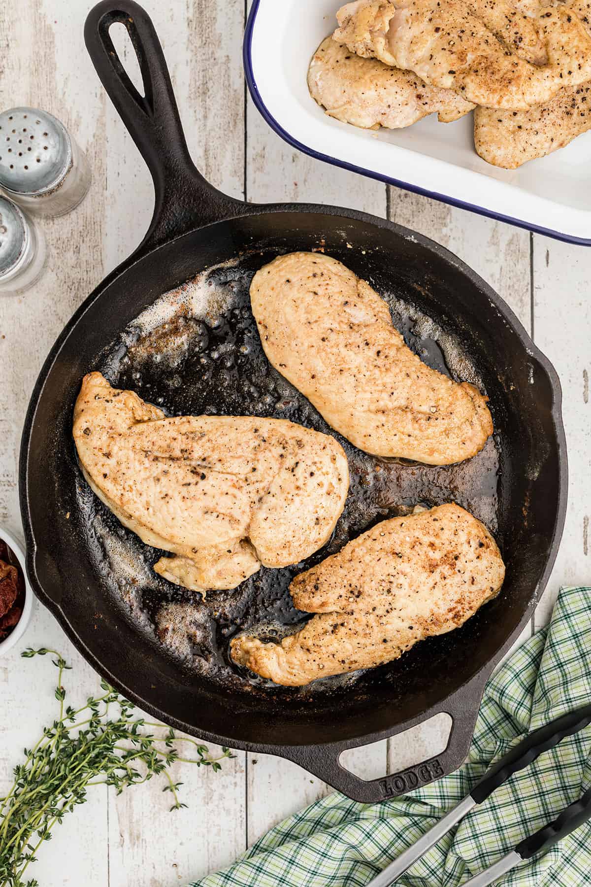 Sauteed chicken breasts in a skillet.