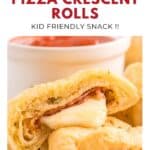 A golden crescent roll filled with pepperoni and melted cheese, with a dip bowl in the background.