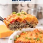 A slice of cheeseburger pie topped with cheese and green onions is lifted from a baking dish.