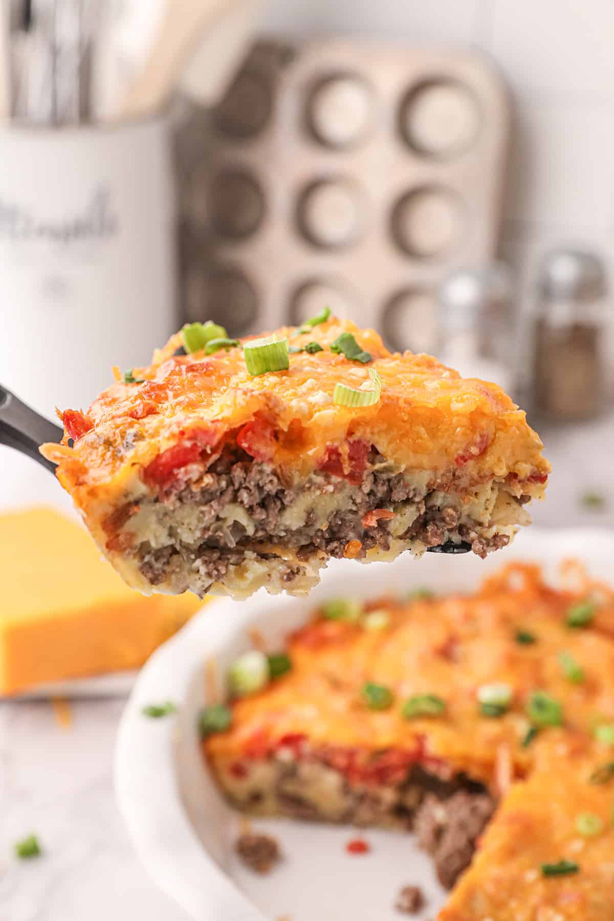 A slice of cheeseburger pie on a spatula.