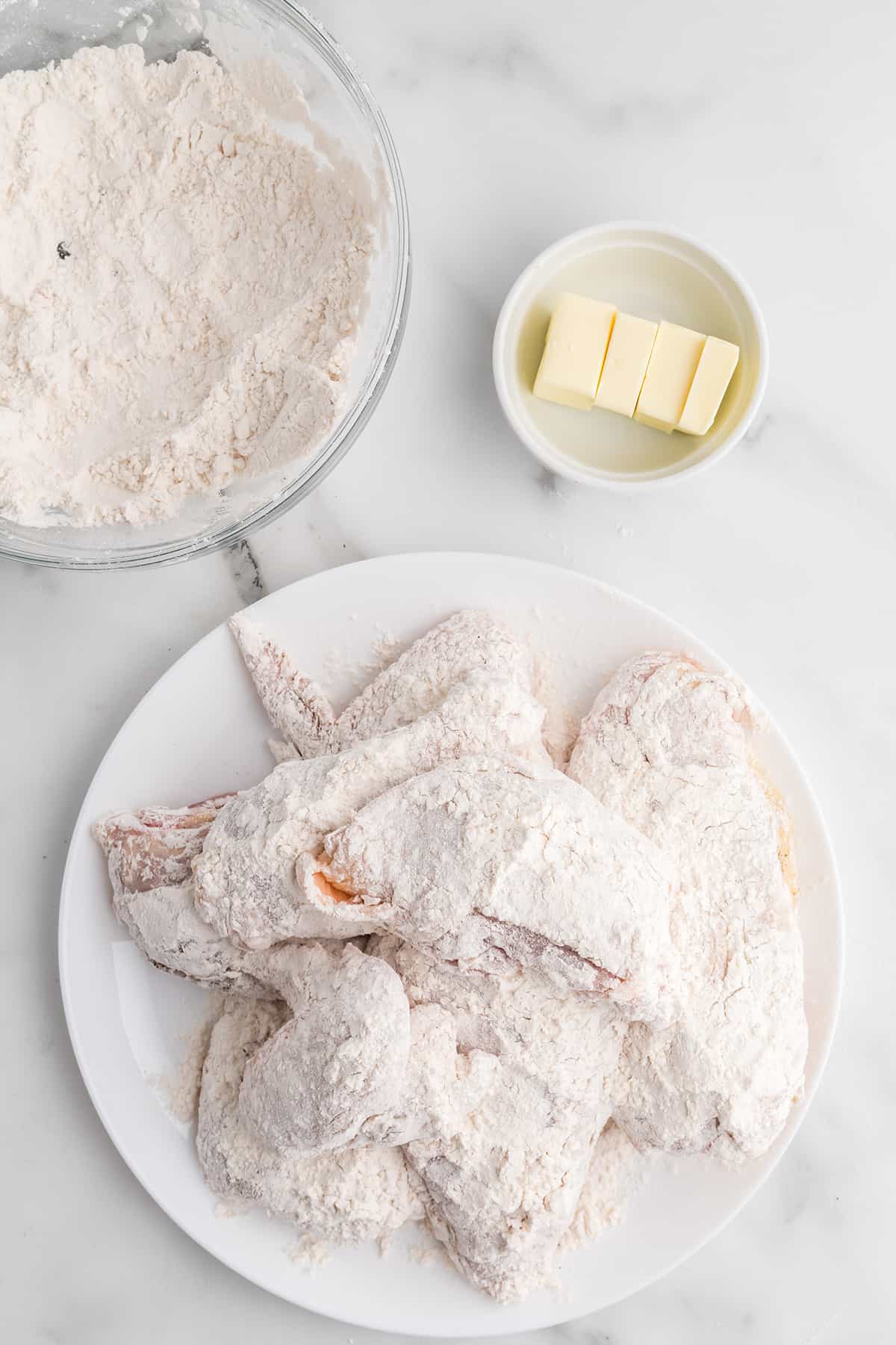 Chicken lightly coated with flour in a bowl.