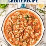 Large pan of Louisiana shrimp creole with tomato sauce and herbs, surrounded by rice and fresh ingredients.