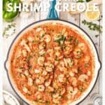 A skillet of Louisiana shrimp creole in tomato sauce, garnished with herbs, surrounded by fresh ingredients.