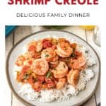 A plate of shrimp creole with tomatoes and peppers served over white rice.