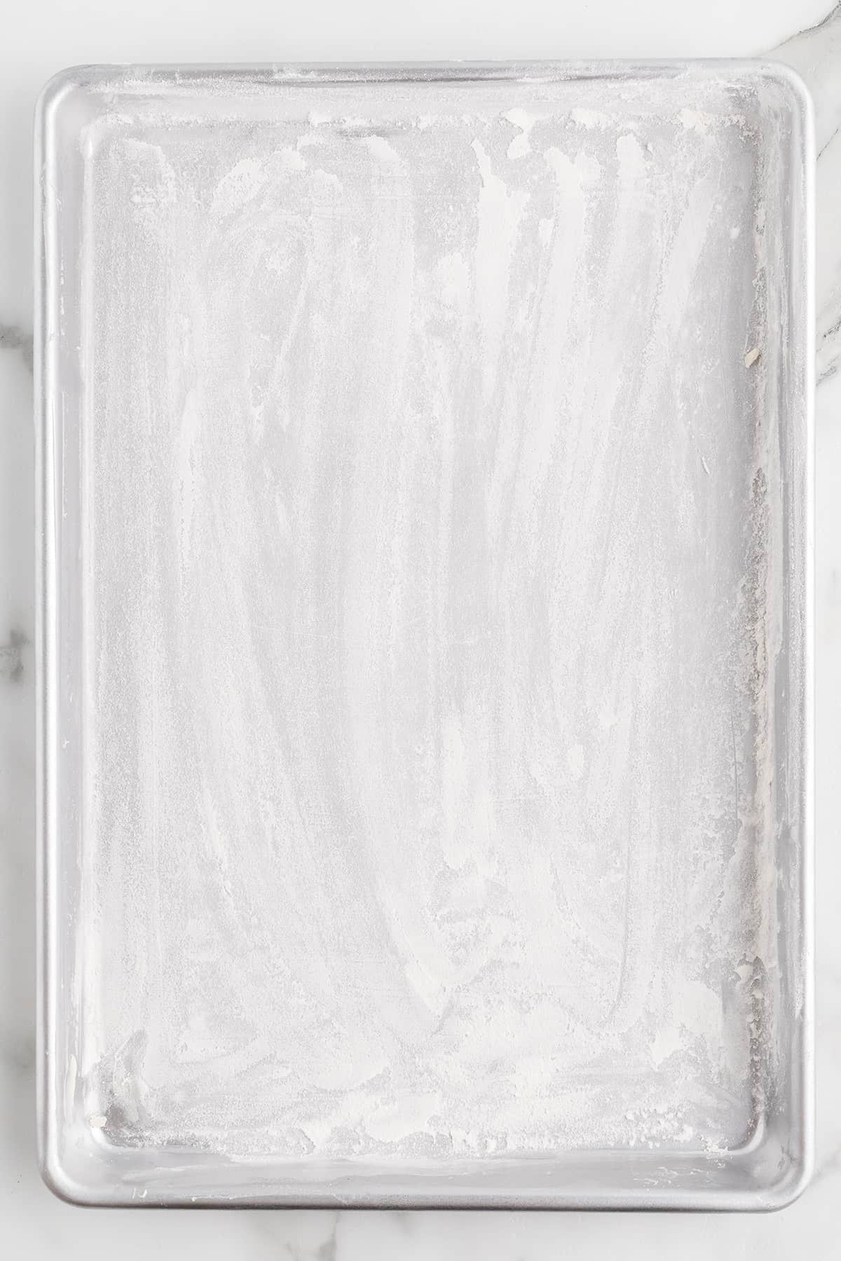 Baking sheet prepared with butter and flour.
