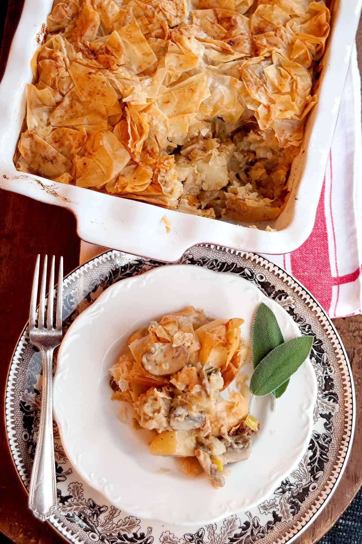 A serving of the finished pie on a white plate with fresh sage on the side.