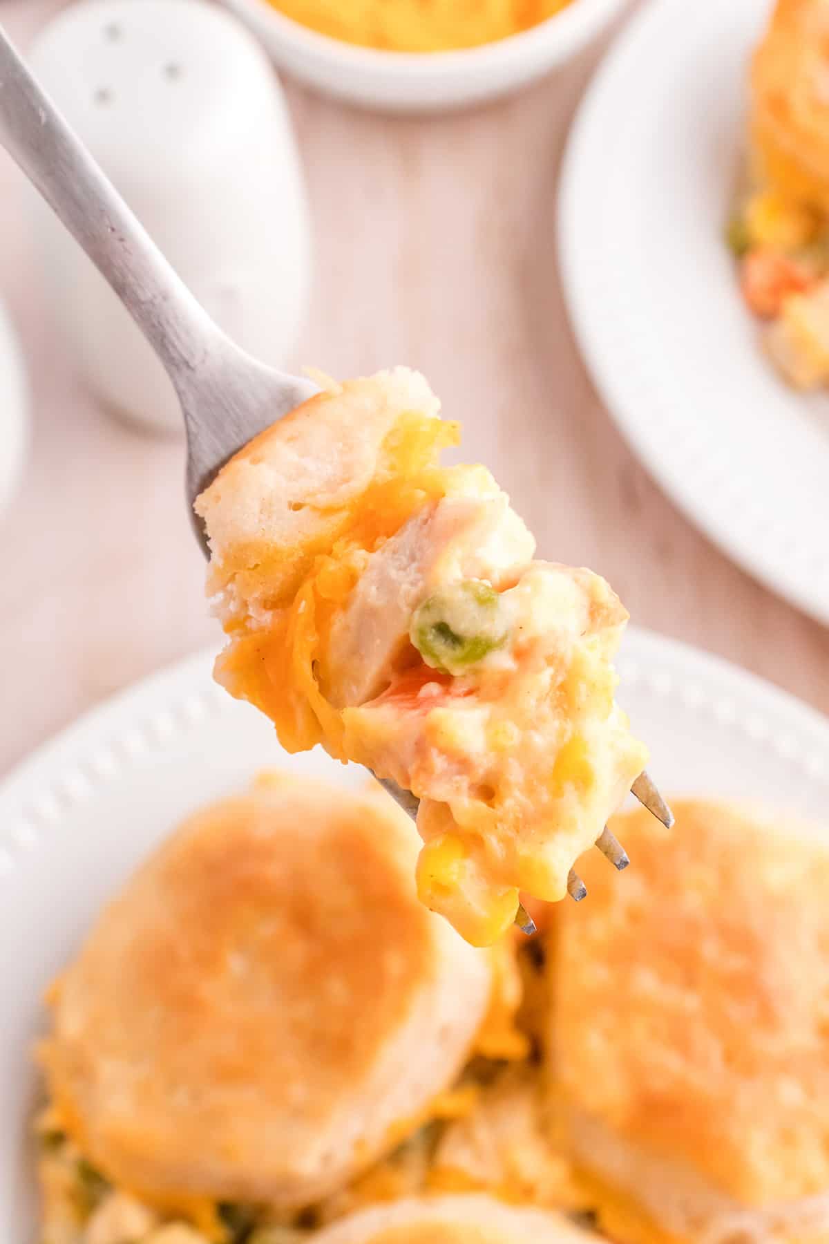 A fork holding a bite of chicken pot pie casserole.