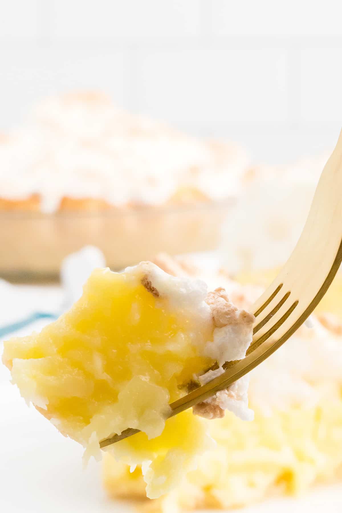 One bite of pie suspended on a gold fork.